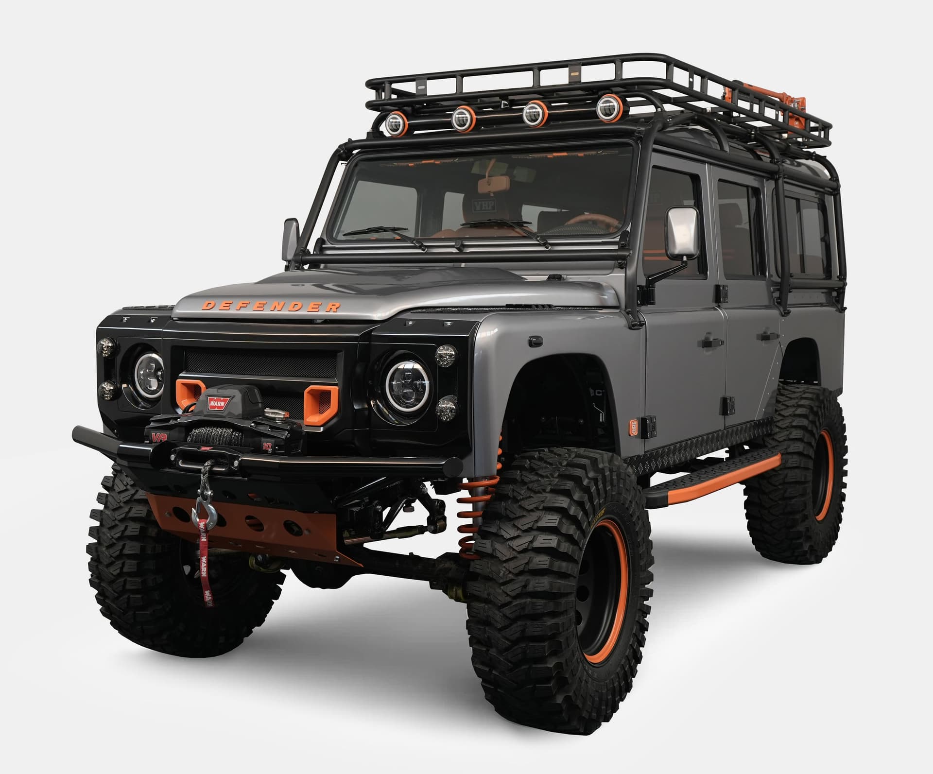 Front view of a bespoke Land Rover Defender with gray exterior and orange accents