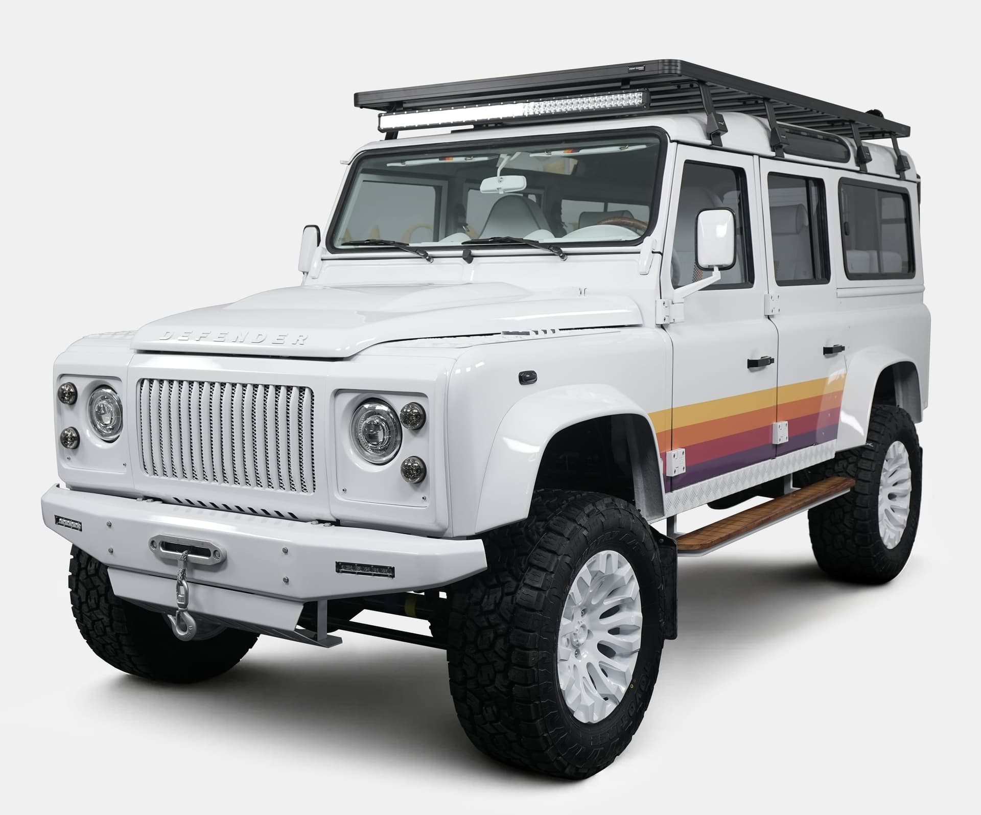 Custom Land Rover Defender in white with retro stripes and off-road tires