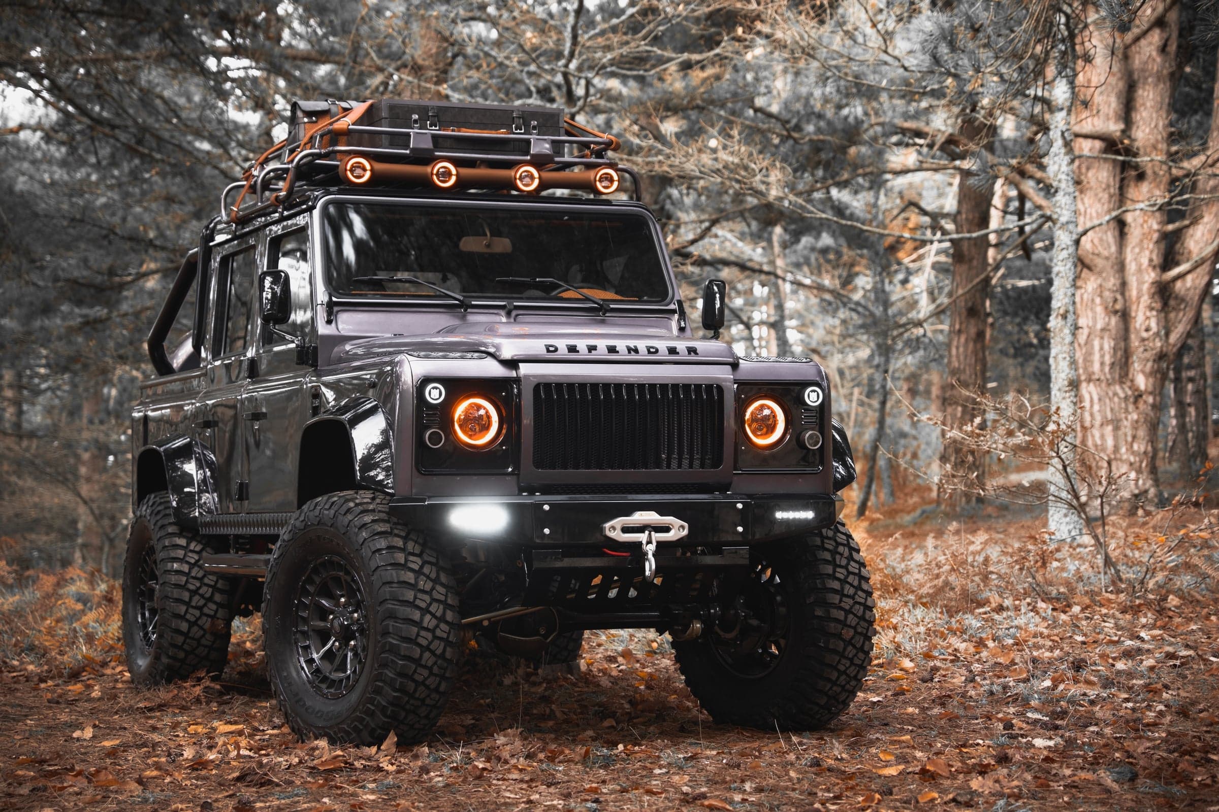 Front profile of a fully restored, custom Land Rover Defender 110 restomod showcasing premium exterior paint and modern lighting upgrades.