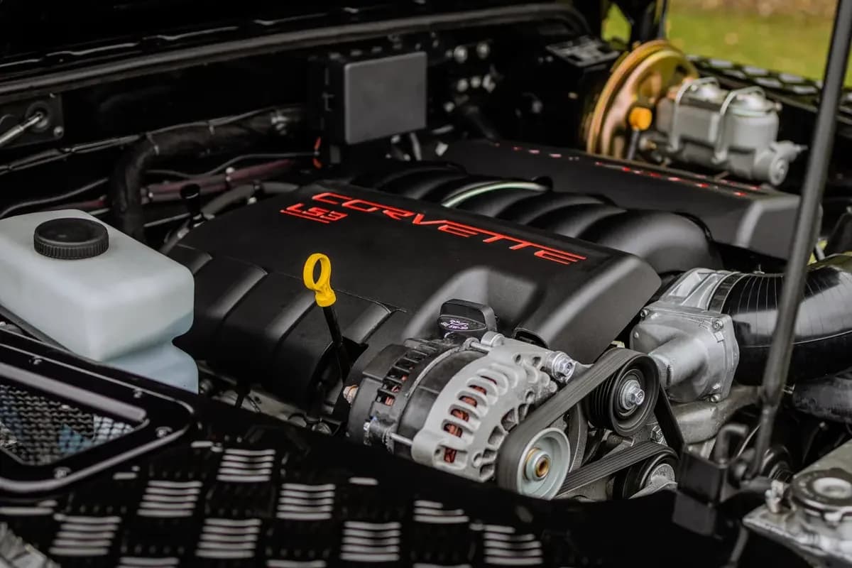 GM LS3 V8 engine swap installed in a classic Land Rover Defender, featuring custom stainless exhaust headers and a bespoke aluminum radiator